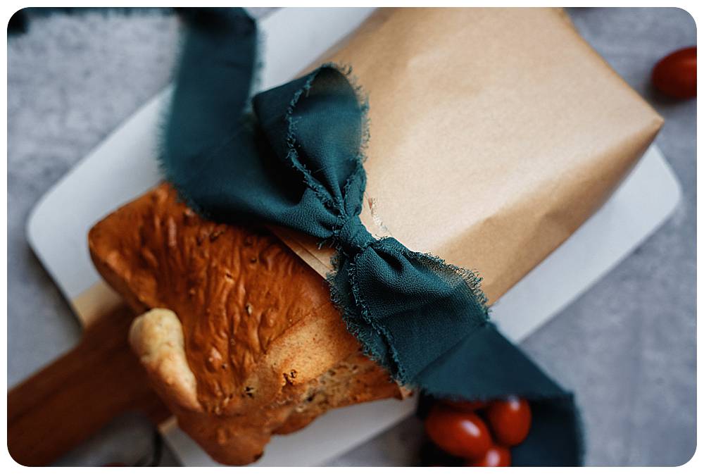 homemade bread wrapped in a. dark green chiffon ribbon for Christmas